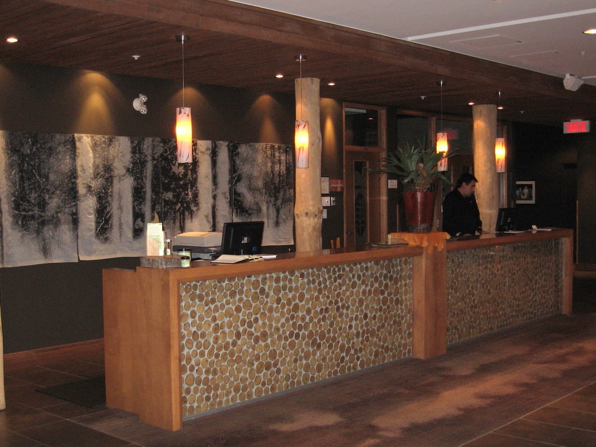 A hotel lobby with timber furniture, a fireplace and reception desk